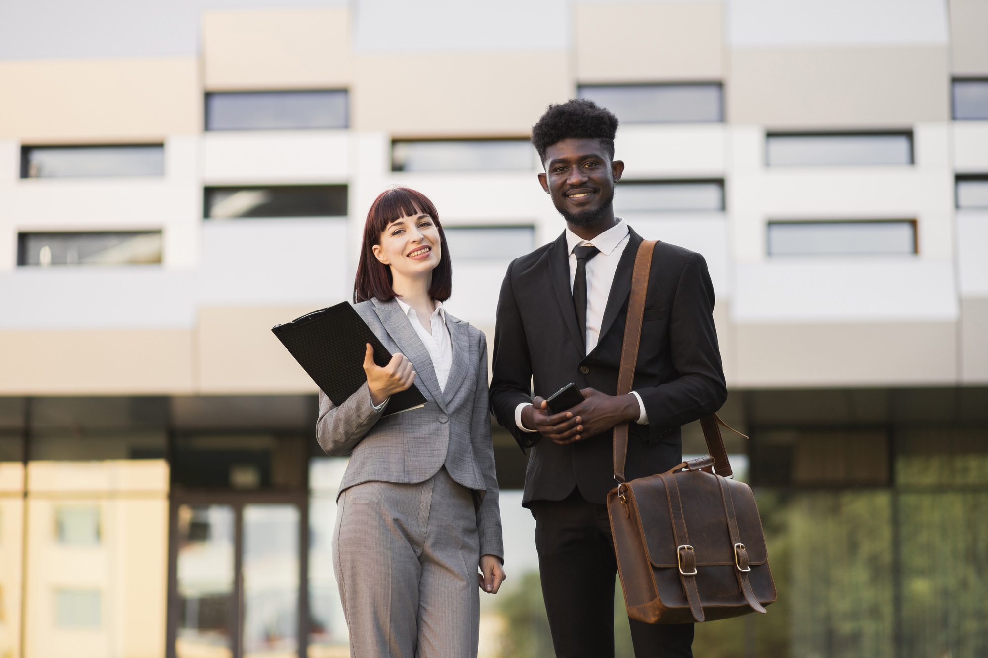 Multiethnic business partners, standing outside modern congress center